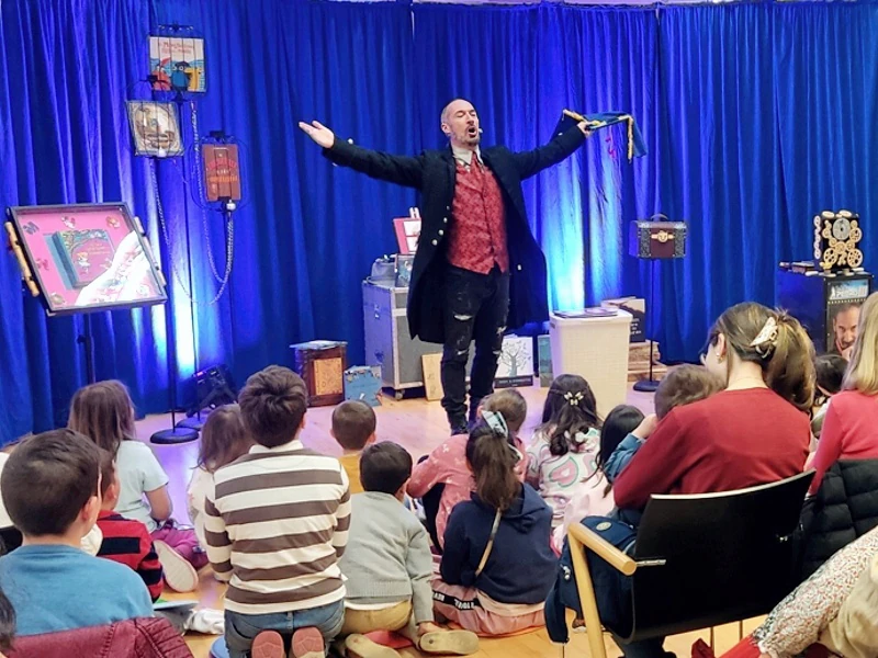 Pedro III abre los brazos en el escenario ante el público sentado en el suelo de la biblioteca